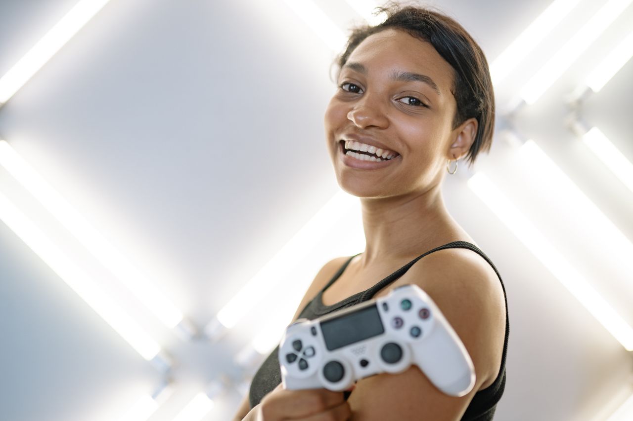 joyful woman holding a game controller in a modern indoor setting