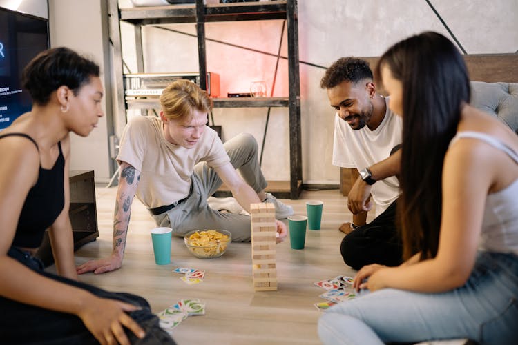 A Group Of Friends Playing Jenga