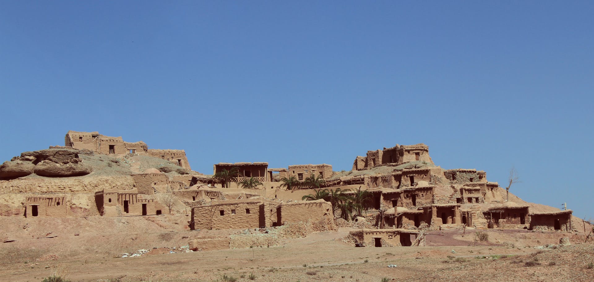 Explore an ancient mudbrick village in Iran, highlighted by a clear blue sky.