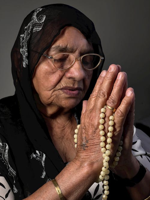 Close-Up Shot of an Elderly Woman in Black Hijab Praying