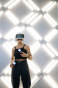 A woman immersed in a virtual reality game using VR headset and controllers against a stylish backdrop.