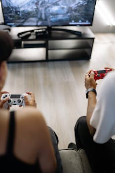 Two friends enjoying video games in a comfortable home environment, focused on intense gameplay.