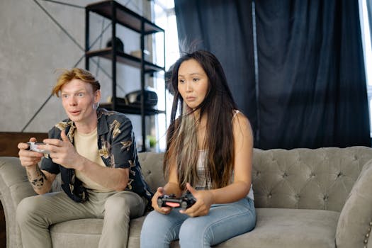 A man and woman playing video games on a couch, immersed in entertainment.