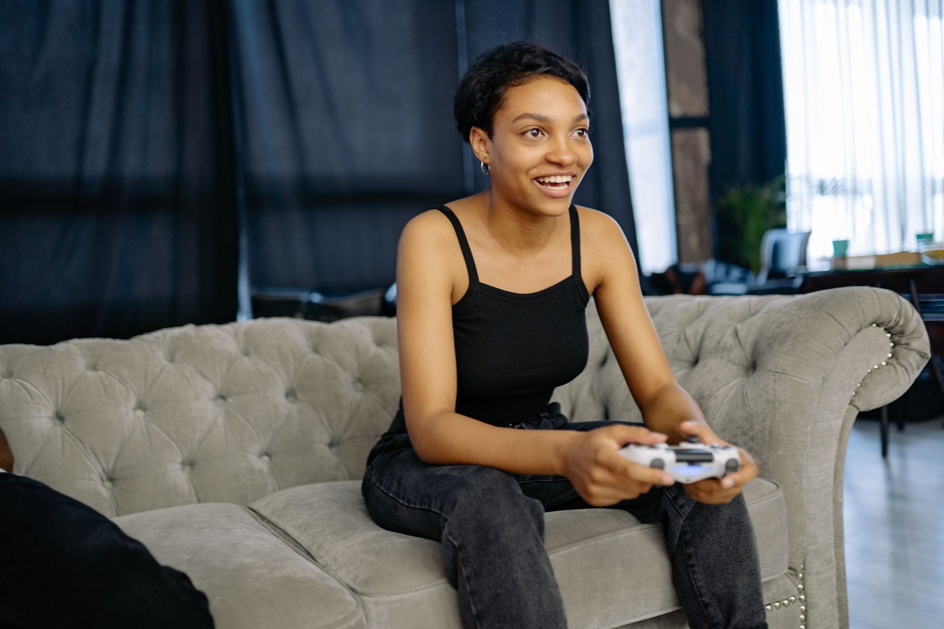 Woman Smiles While Playing a Game Console