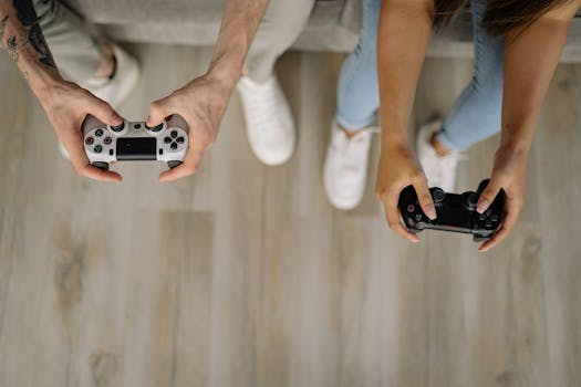 Two individuals holding controllers playing video games indoors, viewed from above.