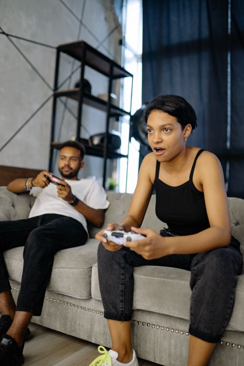 Free A young man and woman deeply engaged in playing a video game indoors. Stock Photo