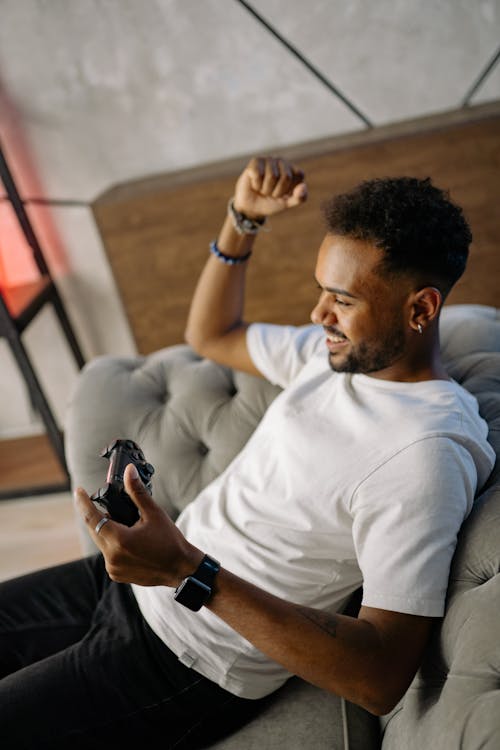 A Man Playing Video Games while Sitting on the Sofa