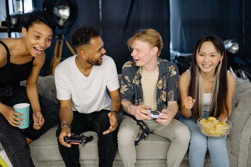 Free A group of diverse friends enjoying a video game session together, laughing and bonding indoors. Stock Photo