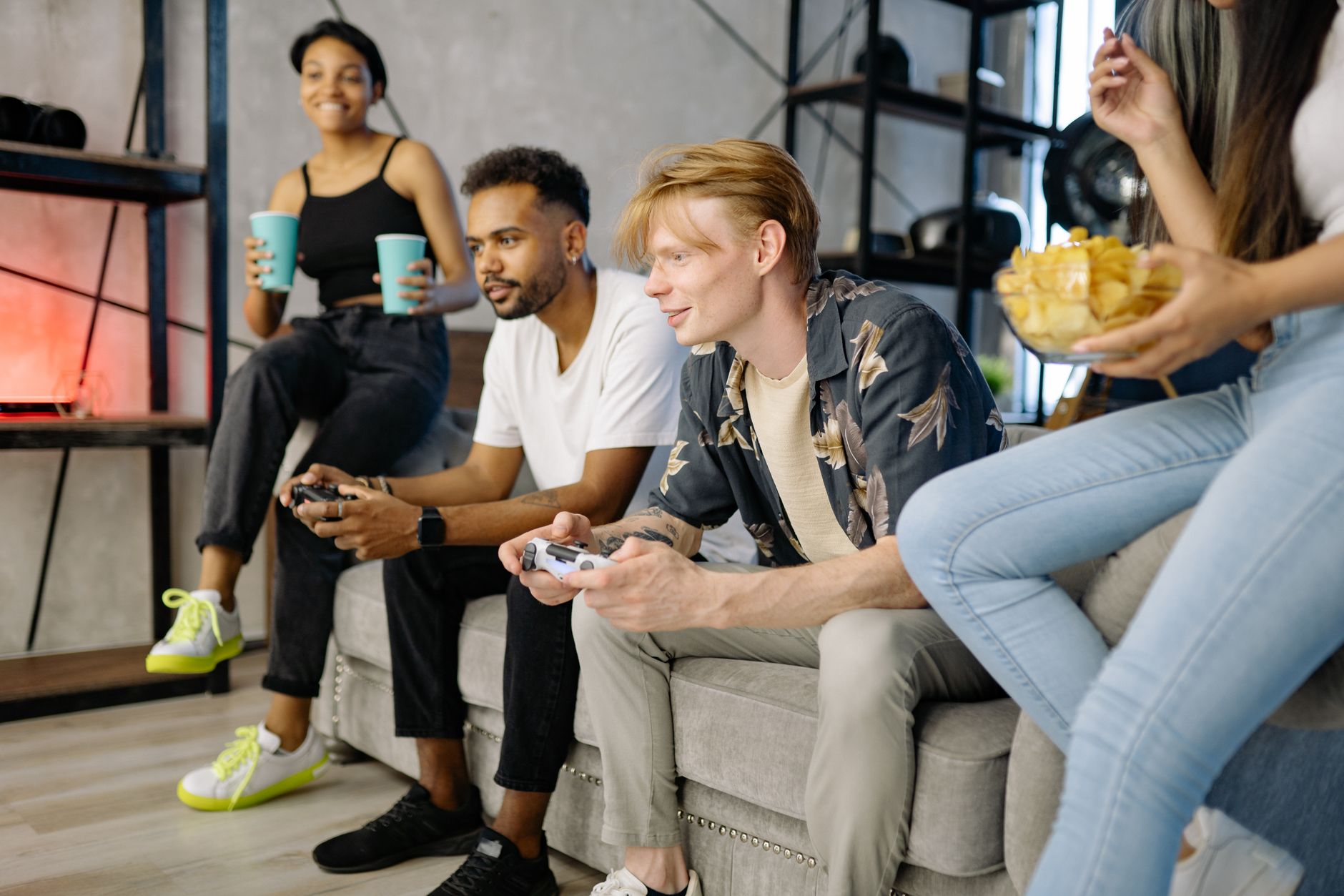 friends gathered around a gaming table, smartphones and snacks nearby, relaxed evening atmosphere