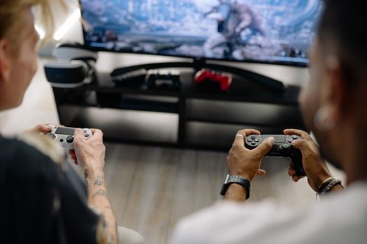 Two friends enjoying a video game session indoors using controllers, focusing on teamwork and fun.