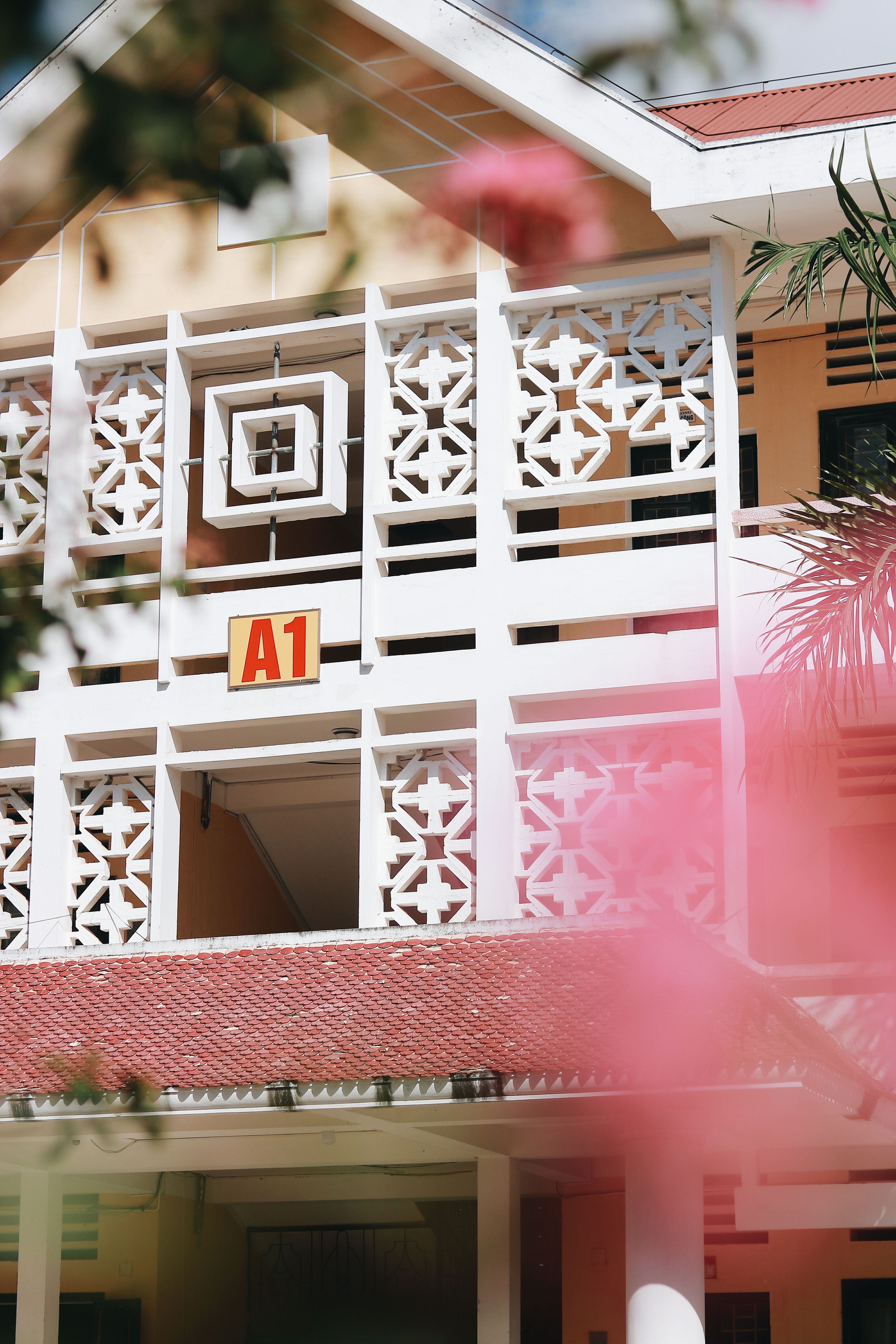 Detailed view of a decorated building facade with ornate balconies and tropical plants.