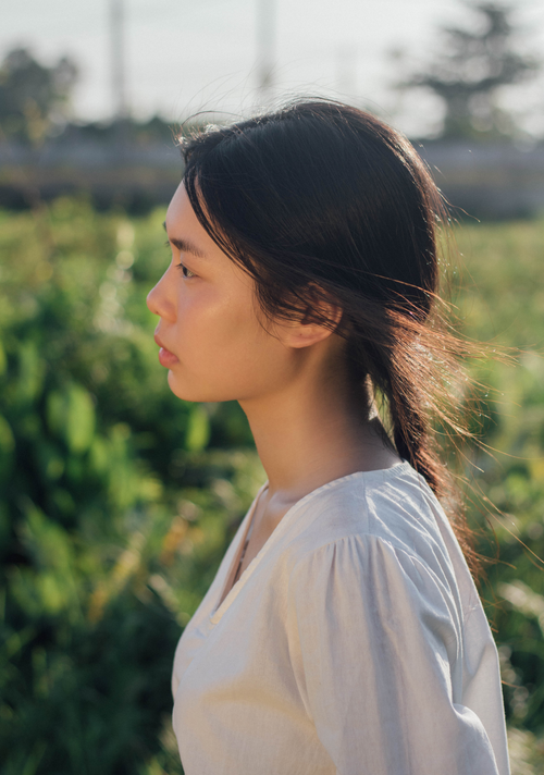 Free Side profile of a young woman outdoors in natural light, reflecting tranquility. Stock Photo