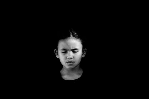 Free Black and white portrait of a young child with eyes closed, reflecting deep thought. Stock Photo