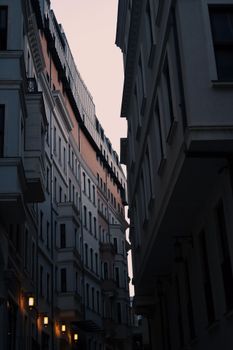 Explore a narrow urban street framed by classic building facades and warm lighting.