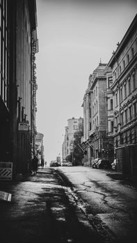 Moody black and white street view in Helsinki, capturing classic architecture and urban life.