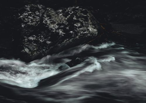 Free Dynamic long exposure of a river flowing over dark rocks, captured in monochrome. Stock Photo