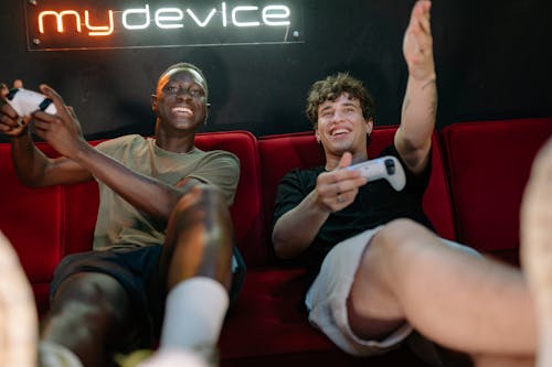Men Sitting on Red Couch Playing a Video Game