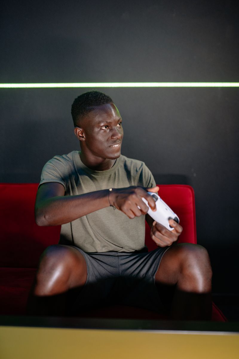 Focused young man engaged in video gaming on a console while seated indoors.