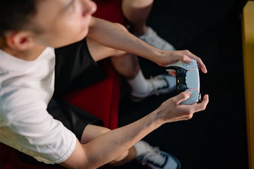 Man in White Shirt Holding a game Controller