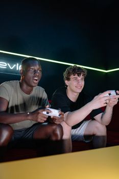 Two men playing video games together, enjoying camaraderie and fun indoors.