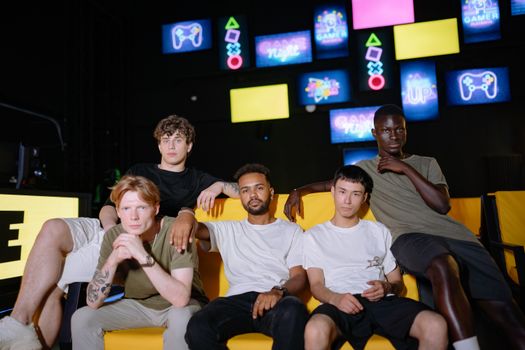 A diverse group of young men sitting together at a gaming event, showcasing friendship and togetherness.