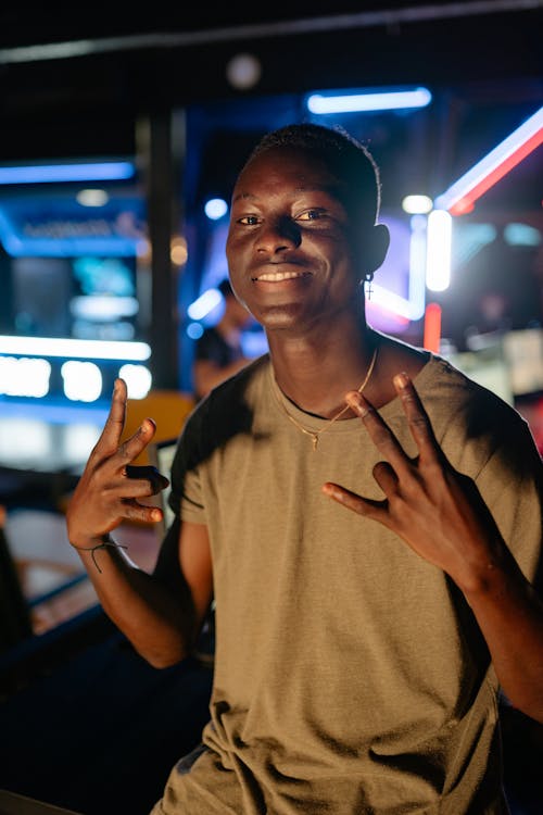 A Man in Brown Shirt Smiling while Doing Hand Gestures