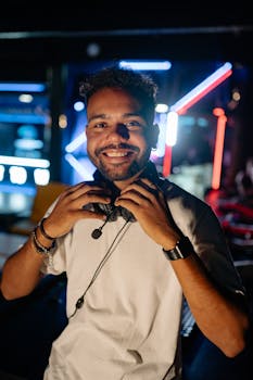 A happy young man wearing a headset enjoys an evening in a vibrant urban setting.