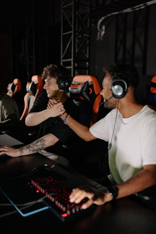 Men Sitting on the Gaming Chair while Wearing Headphones