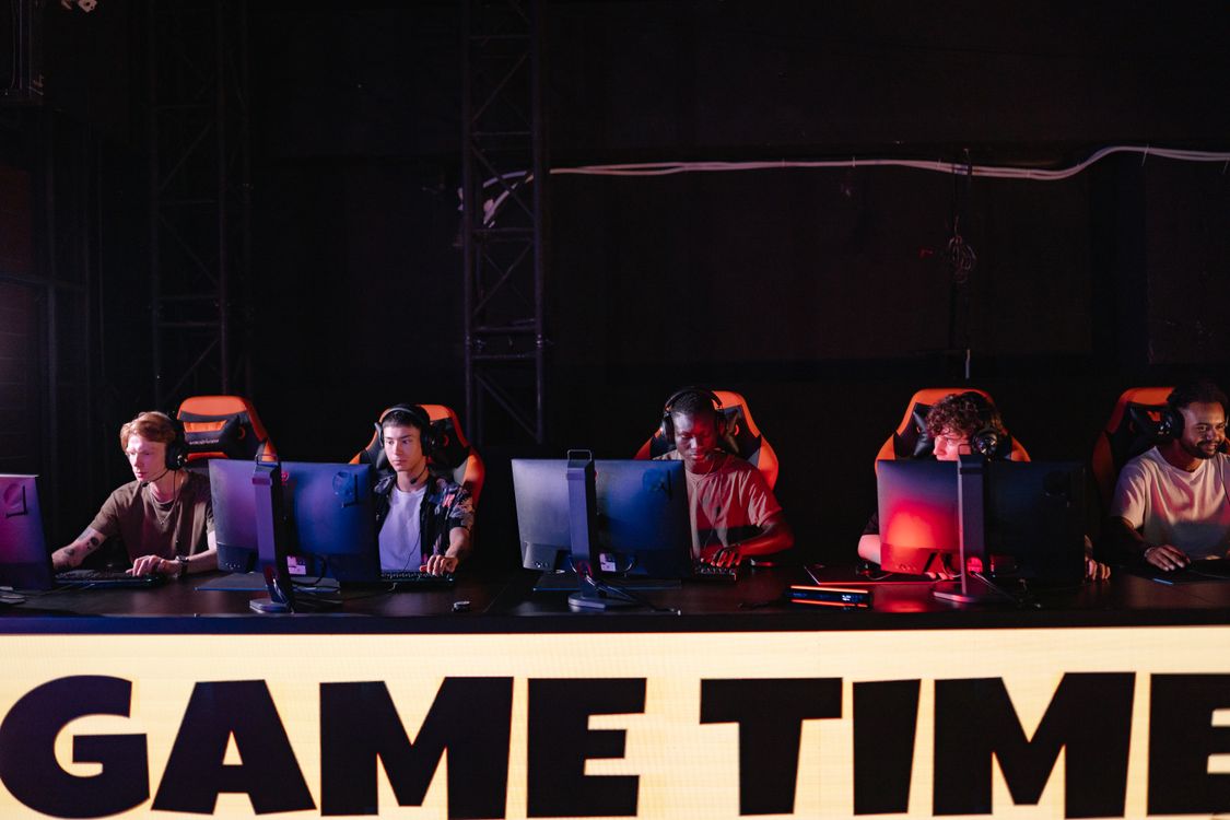 Ekipa igrača za računalima na esports natjecanju, fokusirani na ekrane sa slušalicama