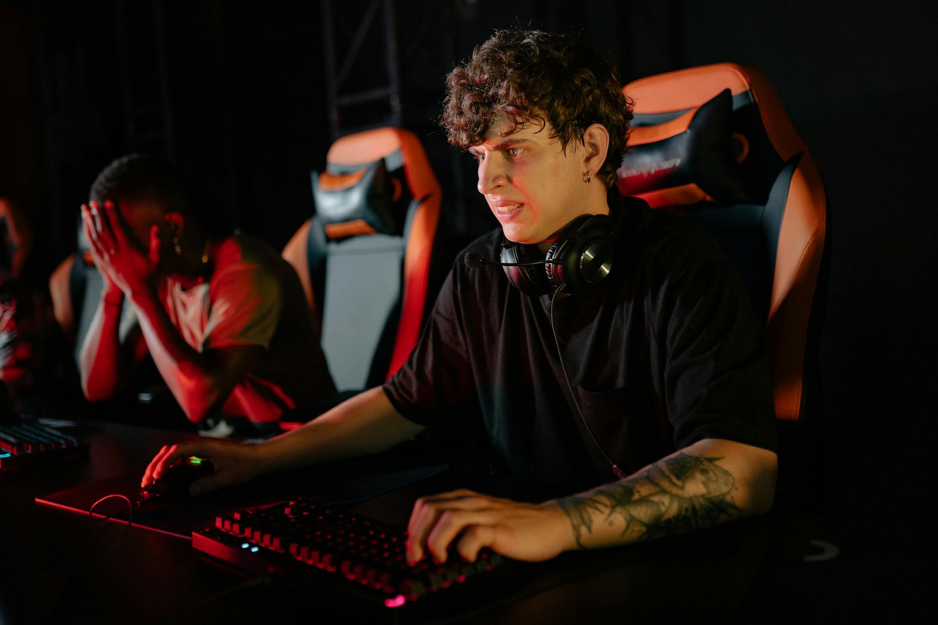 Focused gamers competing in a high-stakes eSports tournament with gaming chairs and headsets.