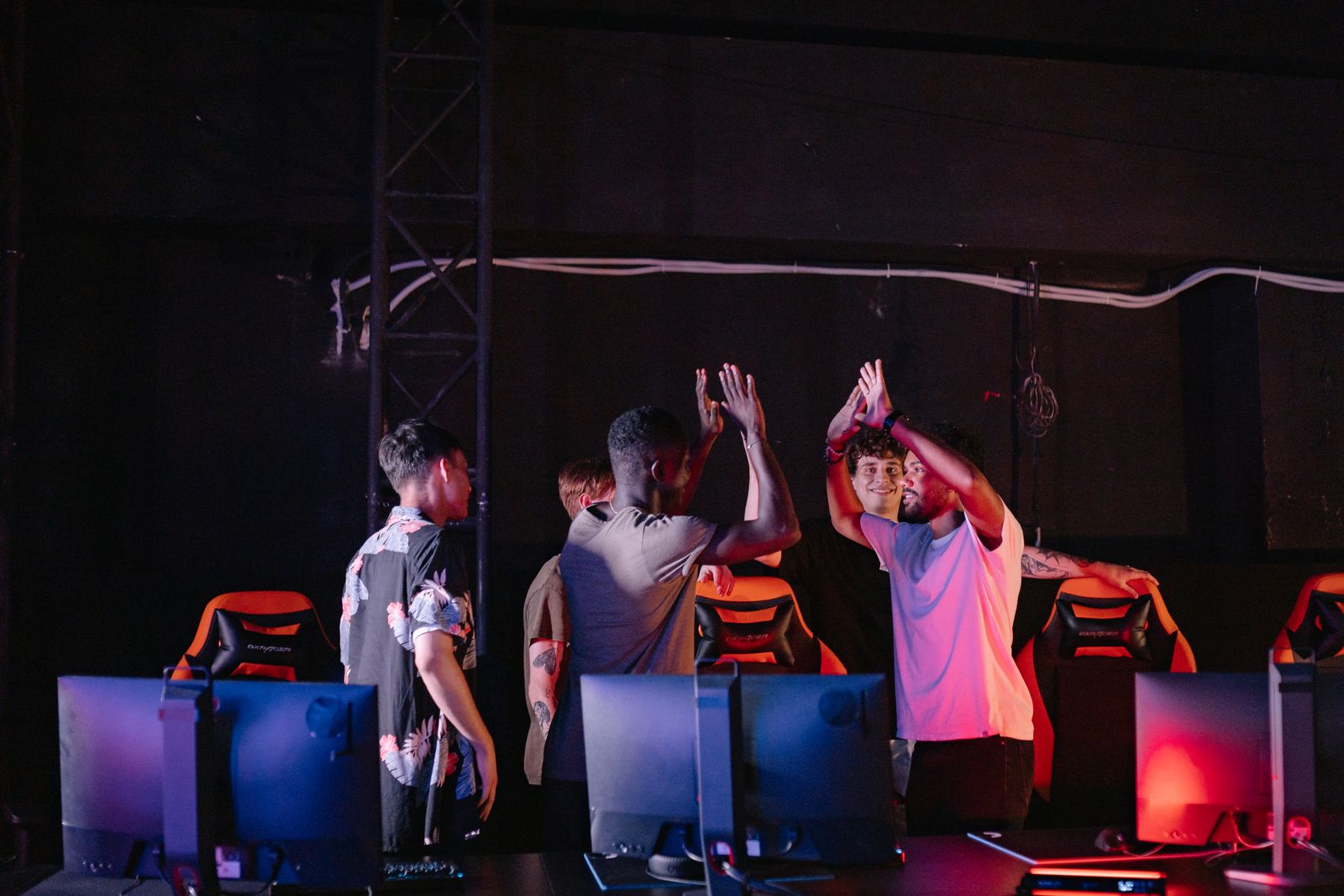 Squad celebrating between gaming stations