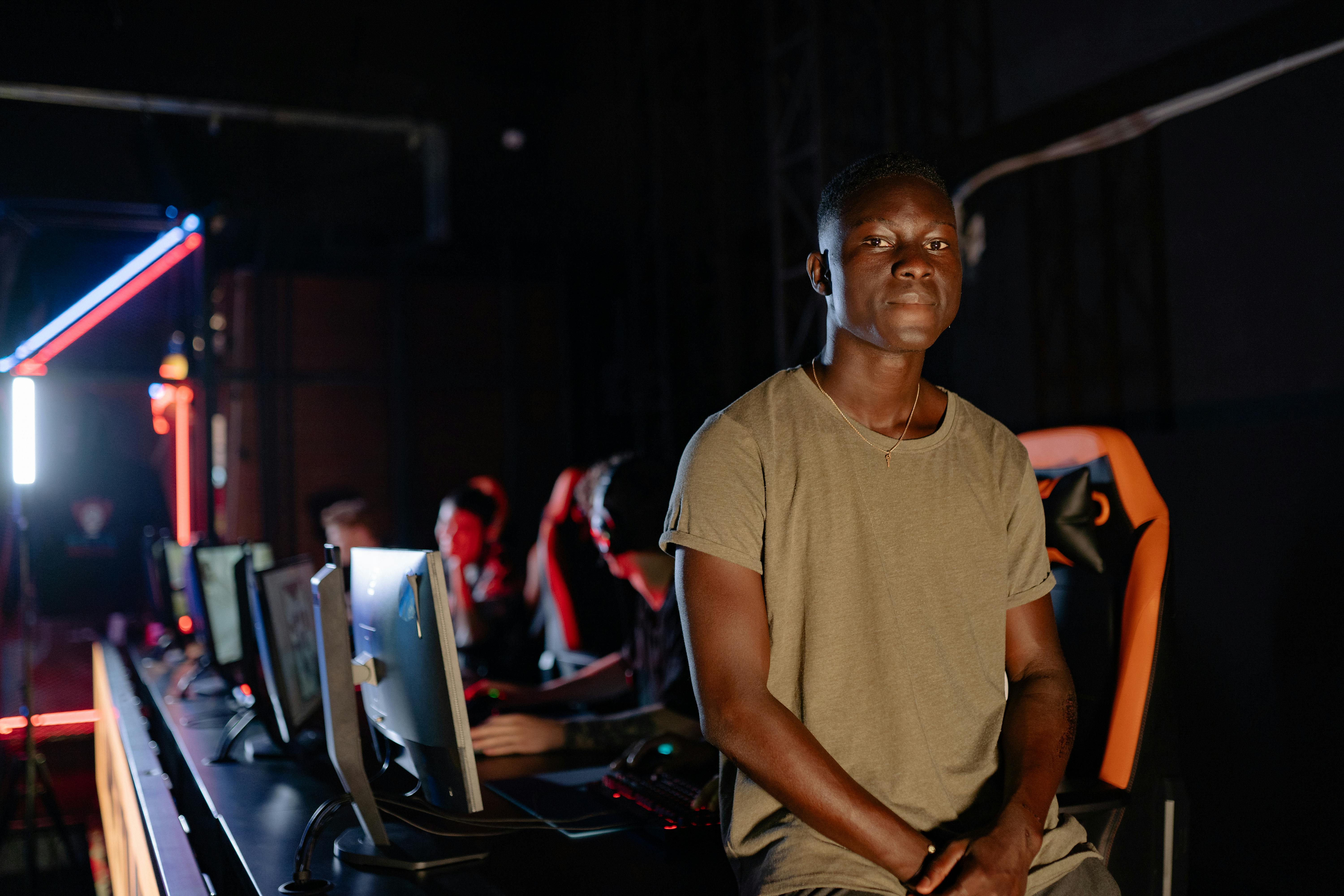 man in brown crew neck t shirt sitting on the edge of the gaming table