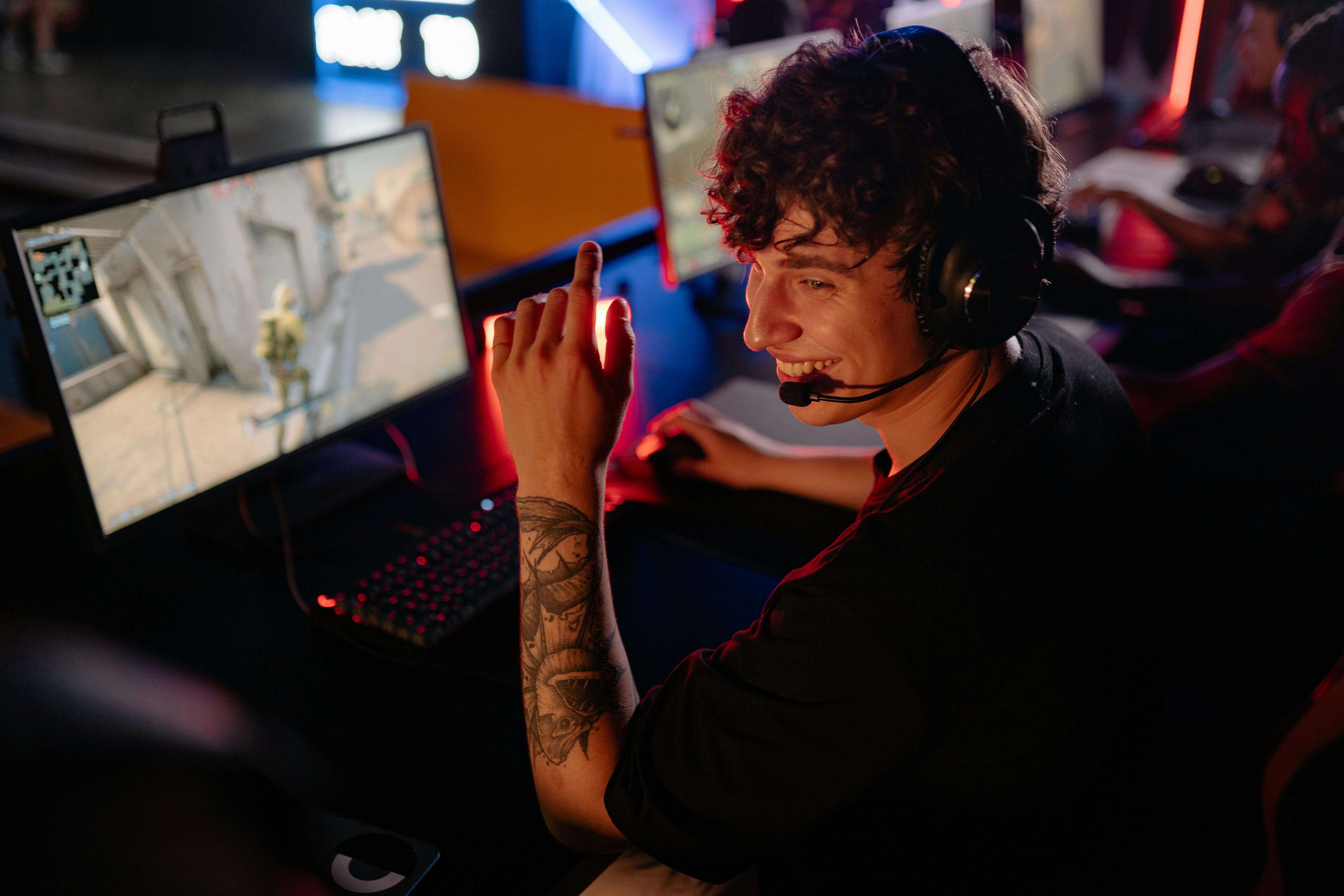 curly haired man in black shirt playing computer game