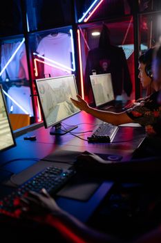 Two gamers engage in a competitive match in a neon-lit gaming space.