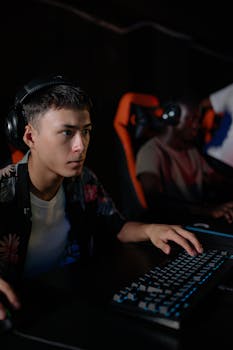 Teenagers engrossed in a competitive e-sports gaming session indoors with gaming setups.
