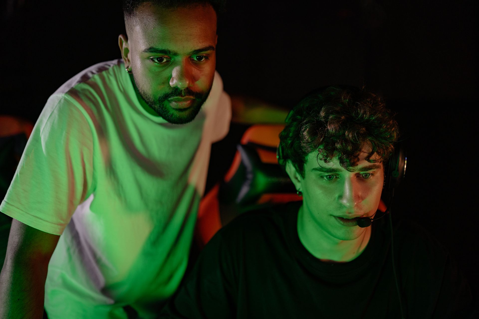 Man Standing Beside the Person Playing Online Games
