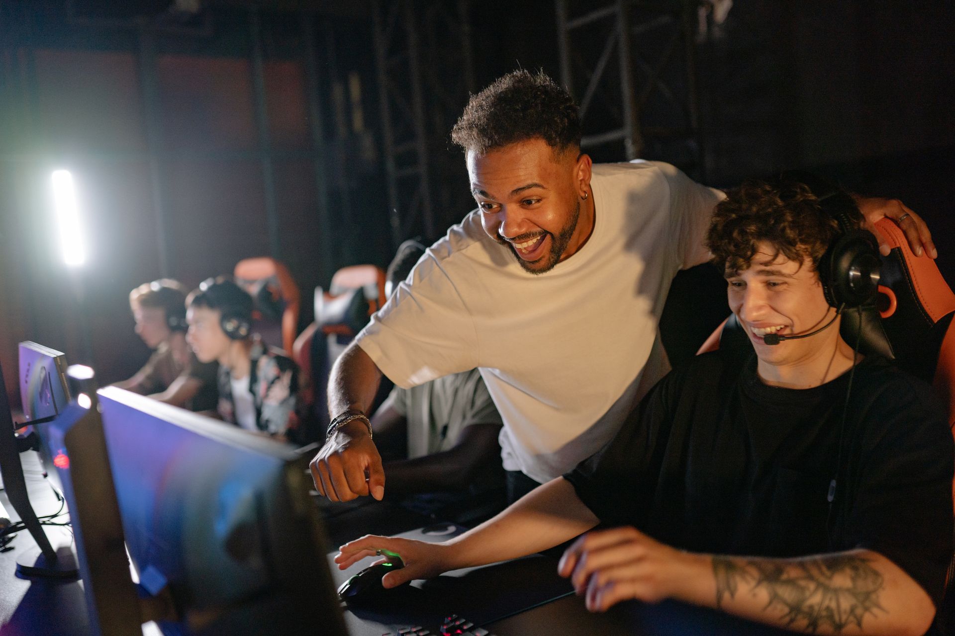 Gamers in a high-energy tournament setting enjoy competitive play with enthusiasm and teamwork.