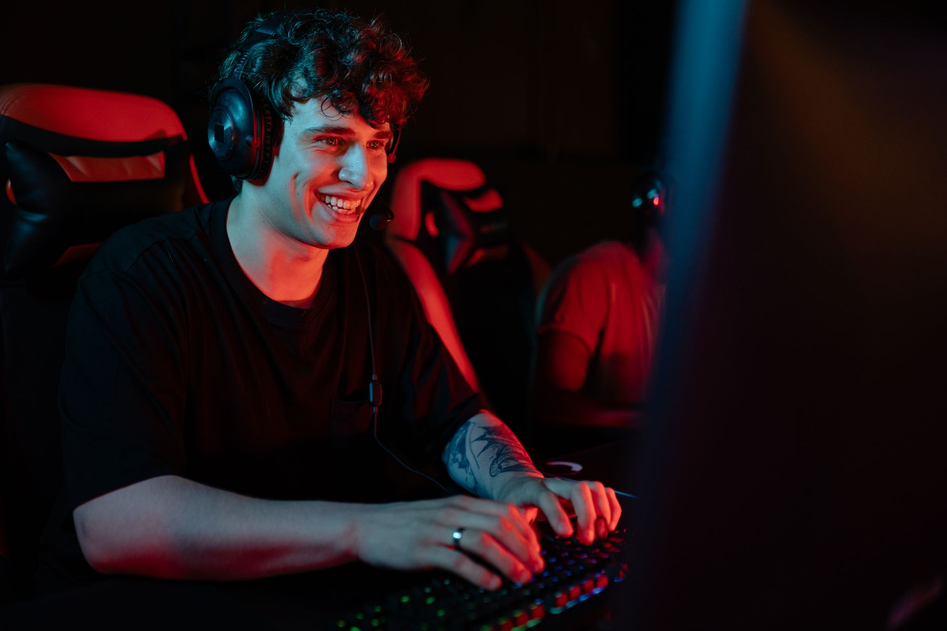 A man enjoying an online gaming session with headphones in a dark room.