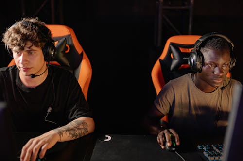 Two Men Wearing Headsets Using Gaming Computers