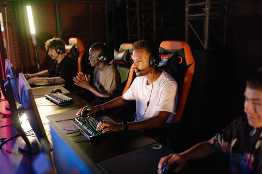 A group of young adults intensely focused on a competitive esports tournament indoors.
