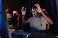 Photograph of a Man in a Gray Shirt Raising His Hands