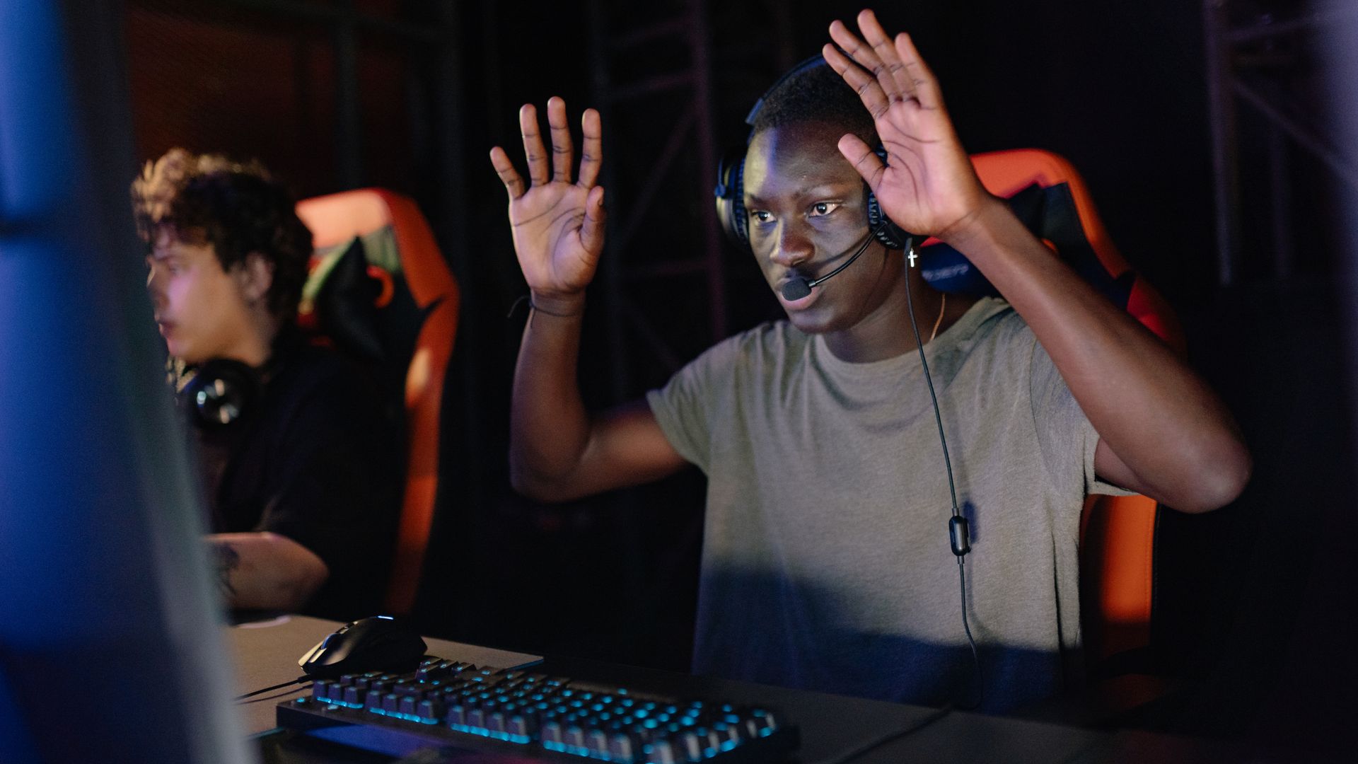 Modafinil for Esports Players: Enhancing Performance African American gamer raising hands while playing on his PC in a gaming tournament — modafinil for esports players