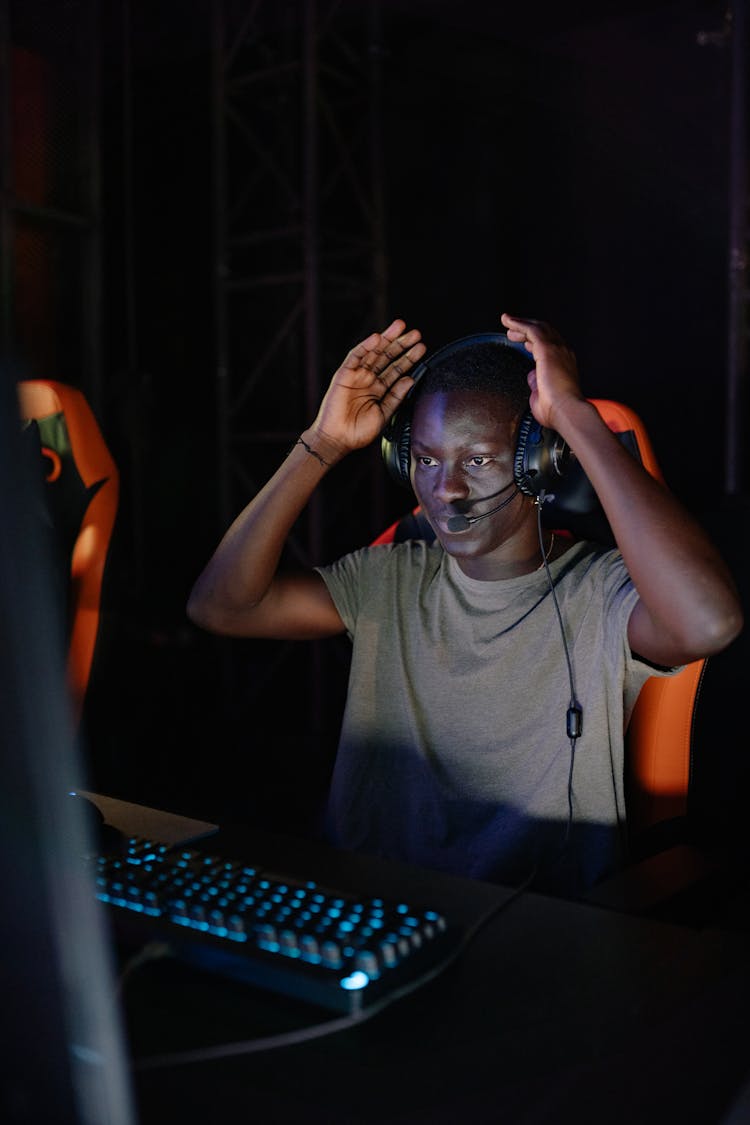 Photo Of A Gamer With A Black Headset Wearing A Gray Shirt