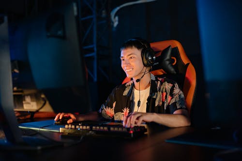 Photo of a Man Playing on a Computer while Smiling