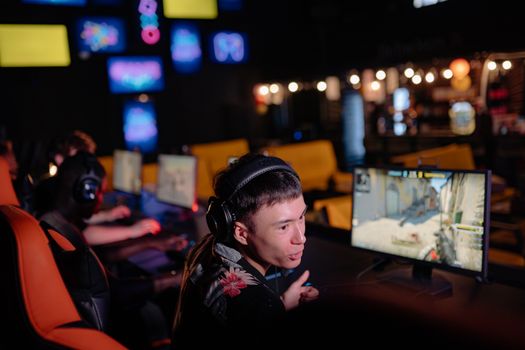 Young adults engaged in competitive gaming at an atmospheric cybercafe, sharing the esports experience.