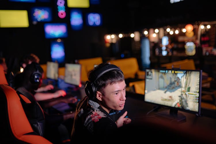 A Man Wearing A Headset In Front Of A Gaming Computer Screen