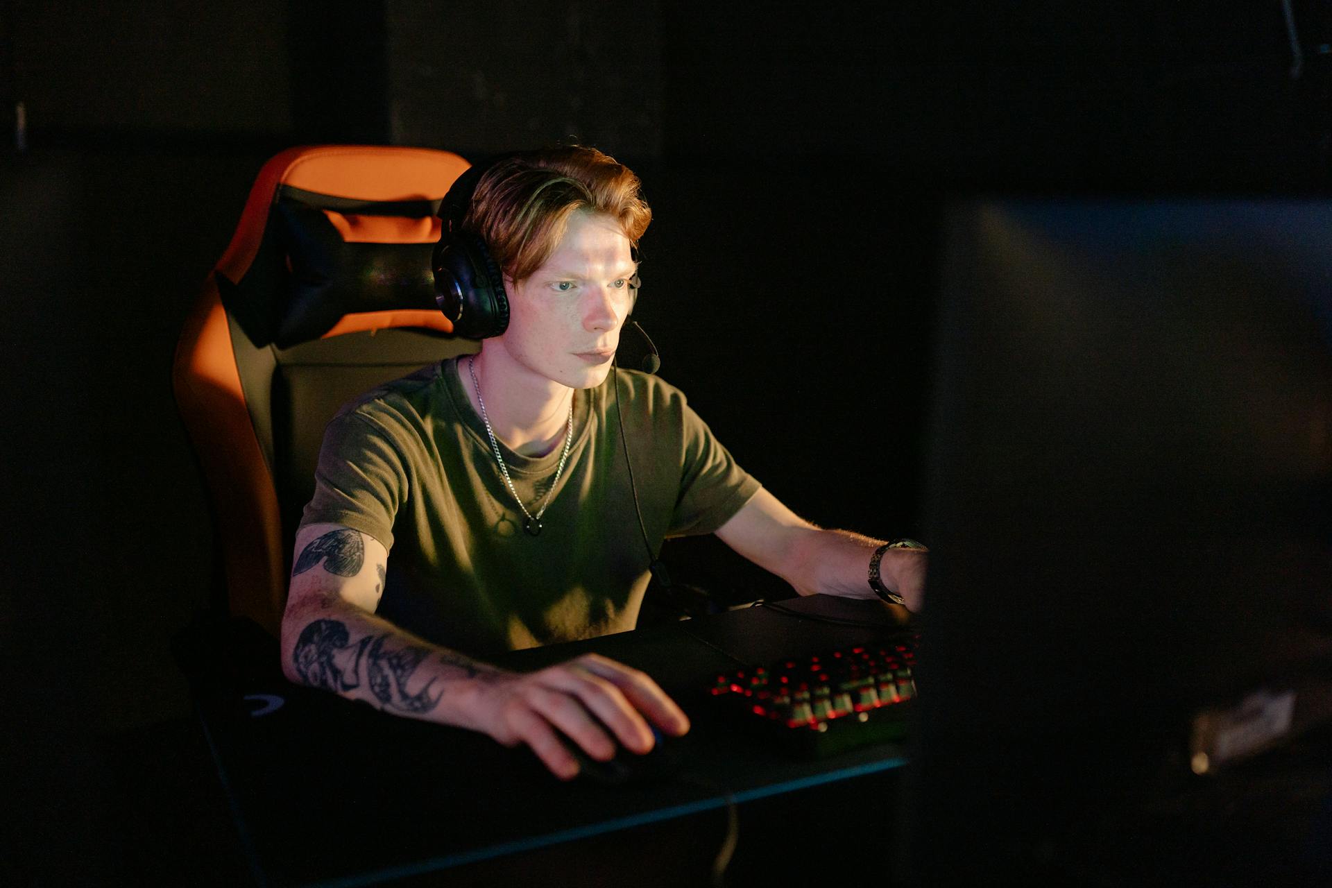 A Man in Green Crew Neck T-shirt Playing Computer Games