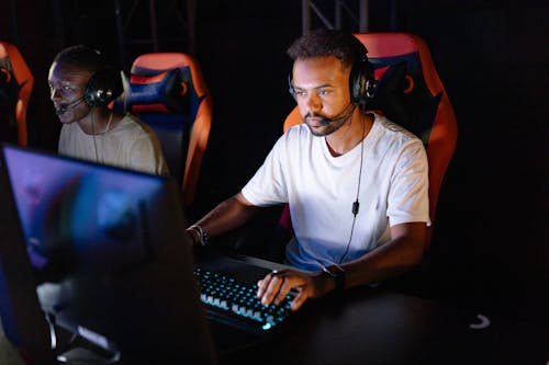 Foto gratuita de un hombre en una camisa blanca jugando en una computadora