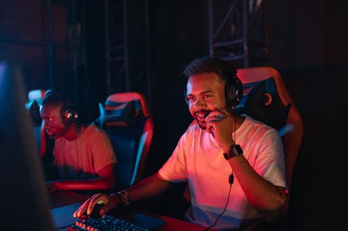 Photo of a Man in a White Shirt Holding the Microphone of His Headset