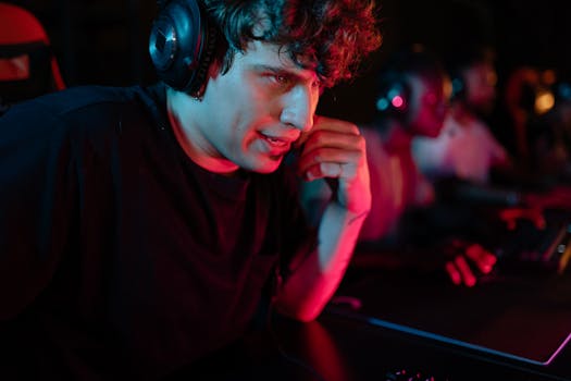 Close-up of a focused gamer wearing a headset in a dimly lit environment, immersed in an intense gaming session.